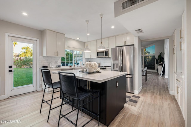 7821 N Via De La Sombre, Scottsdale, AZ 85258 - kitchen featuring appliances with stainless steel finishes, a center island, backsplash, light countertops, and recessed lighting