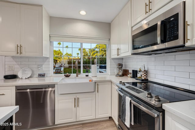 7821 N Via De La Sombre, Scottsdale, AZ 85258 - kitchen with stainless steel appliances, a sink, light countertops, white cabinetry, and recessed lighting