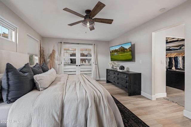 7821 N Via De La Sombre, Scottsdale, AZ 85258 - bedroom with light wood finished floors, baseboards, a spacious closet, a ceiling fan, and a closet