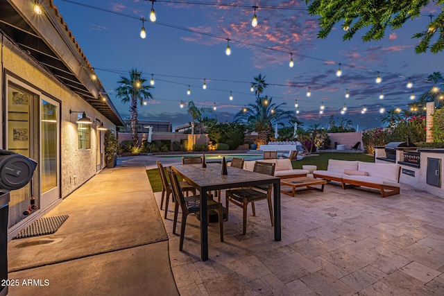 7821 N Via De La Sombre, Scottsdale, AZ 85258 - patio terrace at dusk featuring an outdoor kitchen, a fenced backyard, an outdoor living space, outdoor dining space, and grilling area