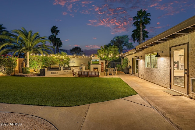 7821 N Via De La Sombre, Scottsdale, AZ 85258 - yard at dusk featuring a patio area, a yard, and area for grilling