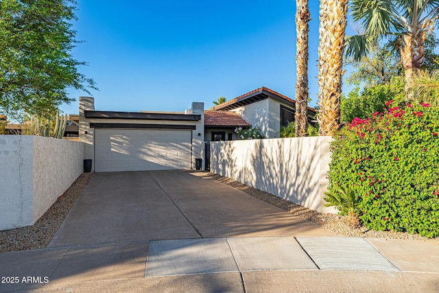 7821 N Via De La Sombre, Scottsdale, AZ 85258 - view of home's exterior with driveway, an attached garage, fence, and stucco siding