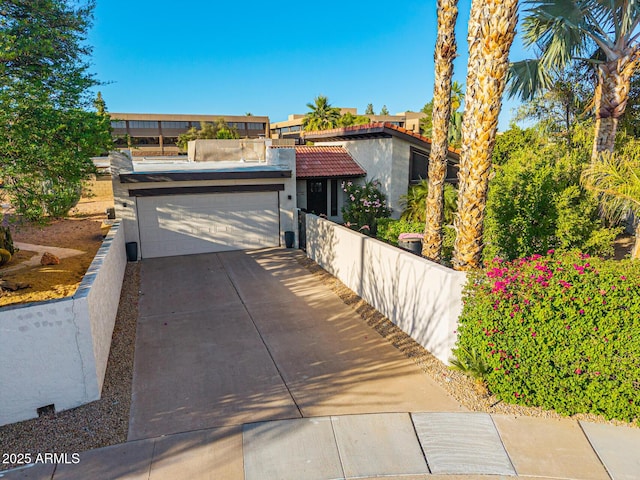7821 N Via De La Sombre, Scottsdale, AZ 85258 - view of front of property with an attached garage, driveway, stucco siding, and fence