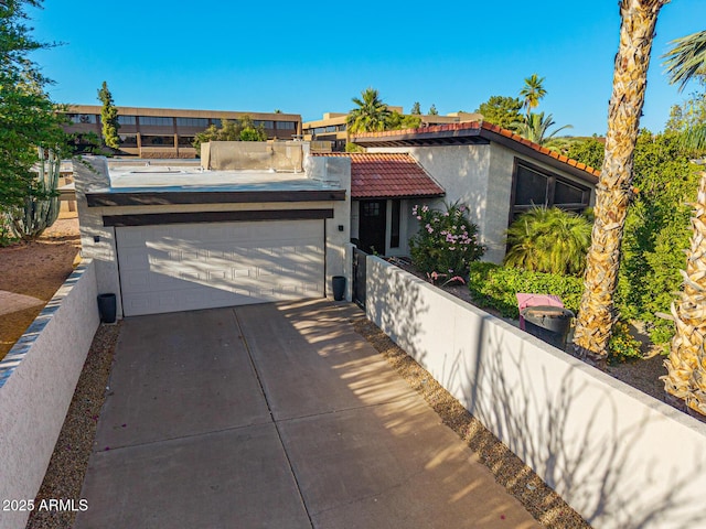 7821 N Via De La Sombre, Scottsdale, AZ 85258 - view of front of property featuring a garage, stucco siding, a tile roof, and concrete driveway