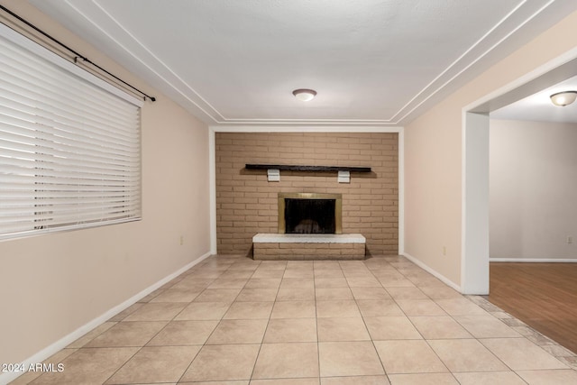 unfurnished living room with a fireplace and light tile patterned floors