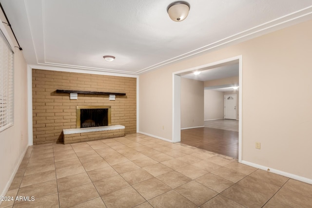 unfurnished living room featuring light tile patterned flooring and a brick fireplace