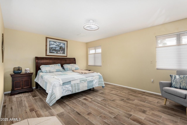 bedroom featuring baseboards and wood finished floors