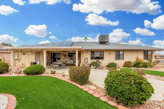 rear view of house with central AC, a lawn, a patio, and solar panels