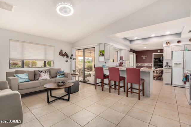 living area featuring light tile patterned floors, lofted ceiling, visible vents, and recessed lighting