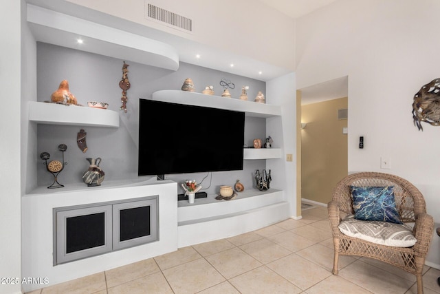 tiled living room with built in features and visible vents