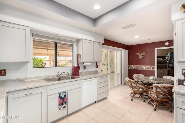 kitchen featuring light tile patterned floors, white dishwasher, a sink, and recessed lighting