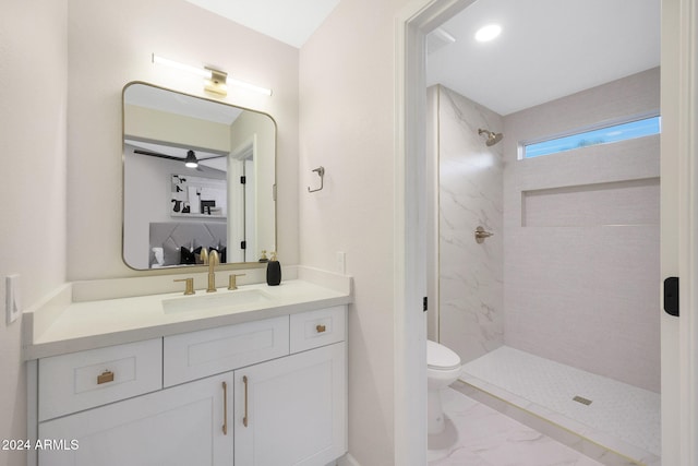 bathroom with vanity, toilet, and tiled shower