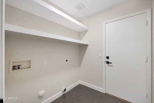 laundry area with electric dryer hookup, gas dryer hookup, hookup for a washing machine, and dark tile patterned flooring