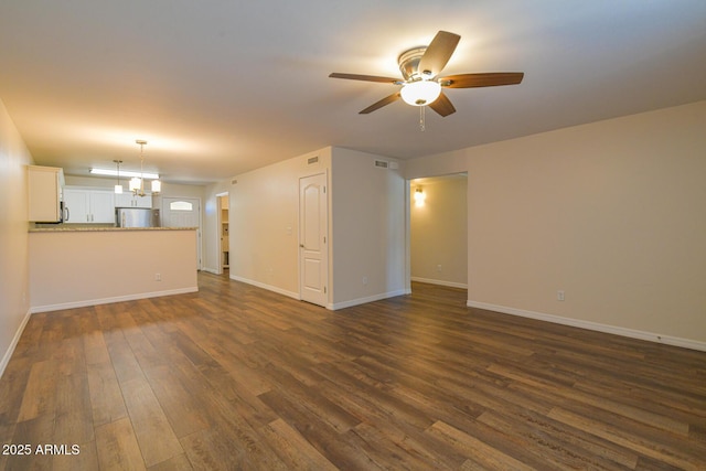 860 W Rd 1 S, Chino Valley, AZ 86323 - unfurnished living room with dark wood-type flooring, baseboards, ceiling fan with notable chandelier, and visible vents