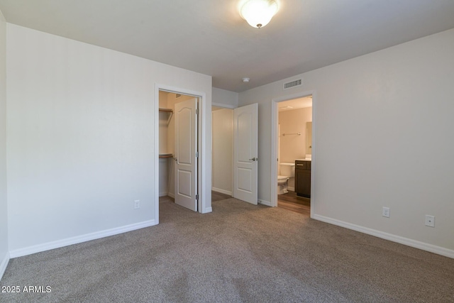 860 W Rd 1 S, Chino Valley, AZ 86323 - unfurnished bedroom with visible vents, carpet floors, baseboards, a spacious closet, and ensuite bath