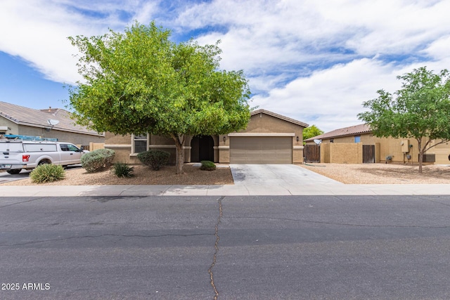 4216 W Harwell Rd, Laveen, AZ 85339 - obstructed view of property featuring an attached garage, driveway, and stucco siding