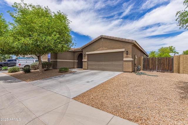 4216 W Harwell Rd, Laveen, AZ 85339 - single story home with concrete driveway, a garage, stucco siding, and a gate