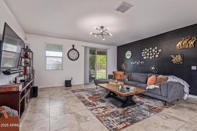 4216 W Harwell Rd, Laveen, AZ 85339 - tiled living room featuring an accent wall, a chandelier, baseboards, and a textured ceiling
