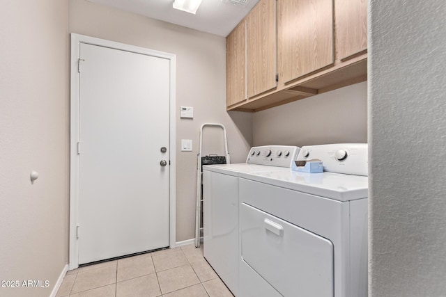 clothes washing area featuring cabinets, light tile patterned floors, and independent washer and dryer