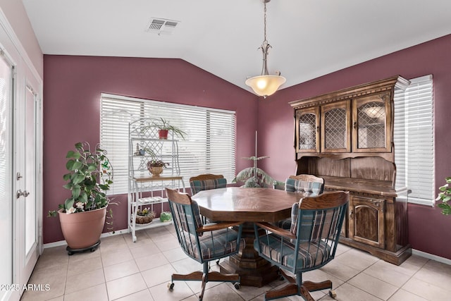 dining area featuring vaulted ceiling and light tile patterned floors