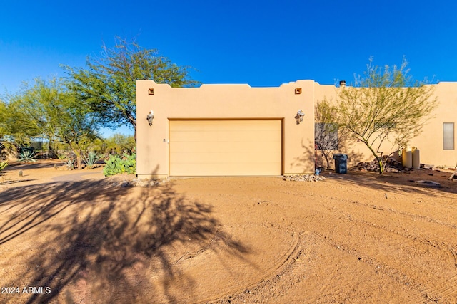 14129 E Barbie Ln, Scottsdale, AZ 85262 - pueblo-style house with stucco siding, dirt driveway, and an attached garage