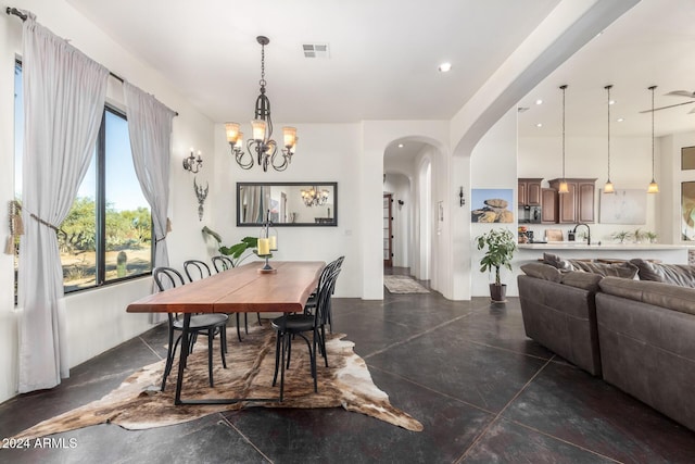 14129 E Barbie Ln, Scottsdale, AZ 85262 - dining room featuring arched walkways, concrete flooring, and a chandelier