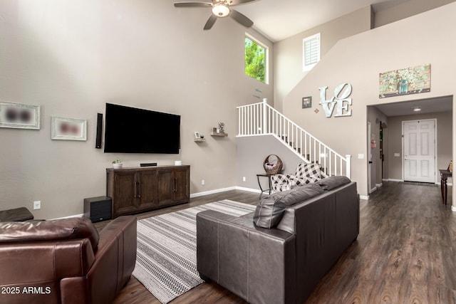 living room with a towering ceiling, ceiling fan, and dark hardwood / wood-style floors