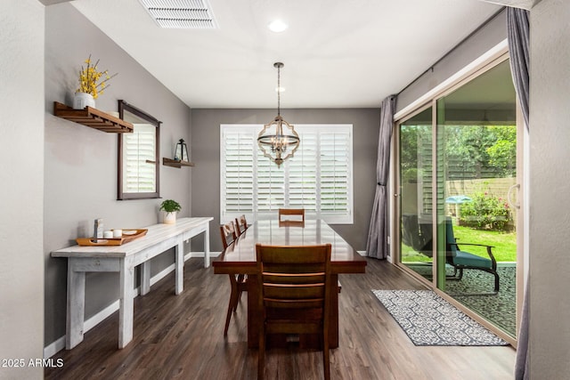 dining area with a notable chandelier and dark hardwood / wood-style flooring