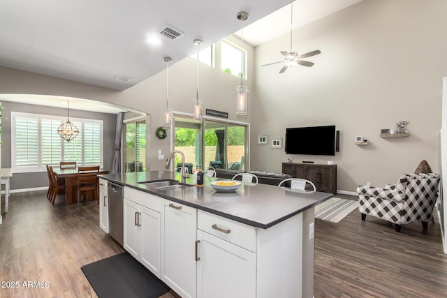 kitchen featuring dishwasher, sink, plenty of natural light, white cabinets, and ceiling fan with notable chandelier