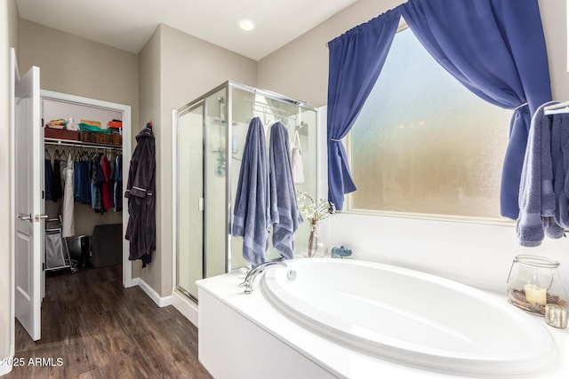 bathroom with hardwood / wood-style flooring and independent shower and bath