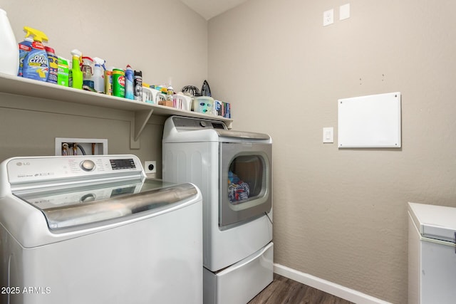 clothes washing area with washer and clothes dryer and dark hardwood / wood-style floors