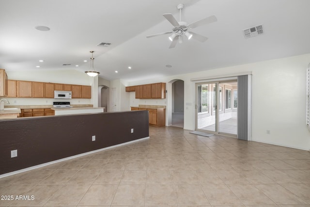 kitchen featuring sink, vaulted ceiling, hanging light fixtures, stainless steel stove, and ceiling fan