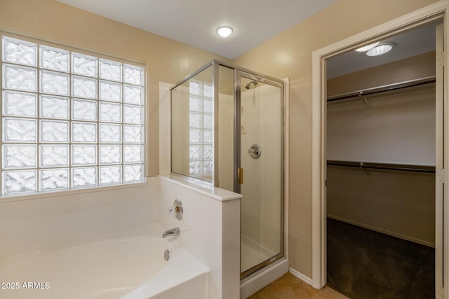 bathroom with tile patterned flooring, separate shower and tub, and plenty of natural light