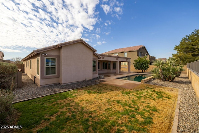 back of house featuring a fenced in pool, a yard, and a patio area