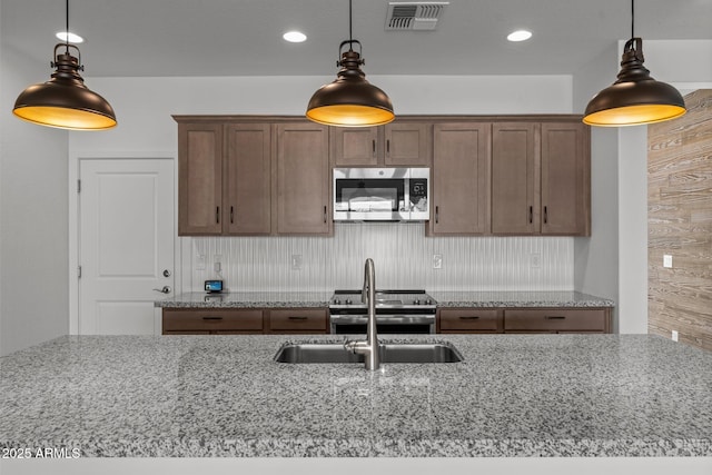 4539 Charro Ct, Wickenburg, AZ 85390 - kitchen with stainless steel appliances, light stone countertops, pendant lighting, and recessed lighting