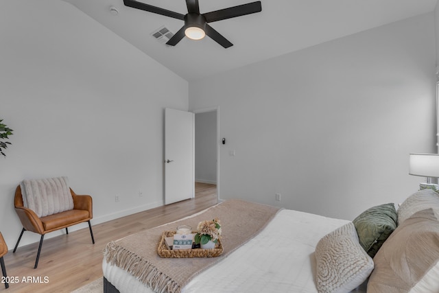 bedroom featuring ceiling fan, visible vents, baseboards, vaulted ceiling, and light wood finished floors