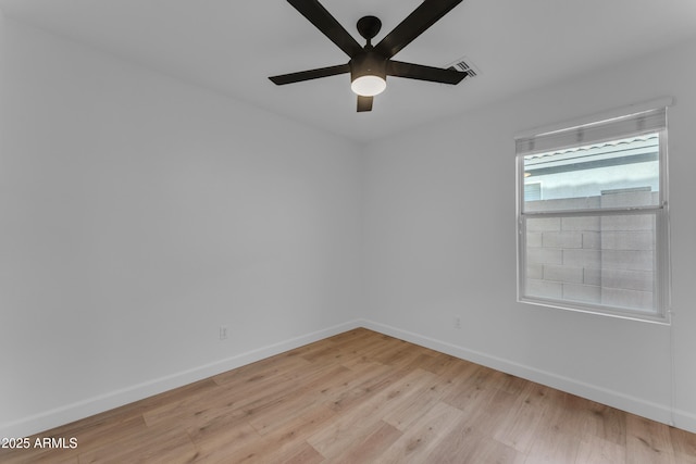 empty room featuring light wood-style floors, visible vents, baseboards, and a ceiling fan