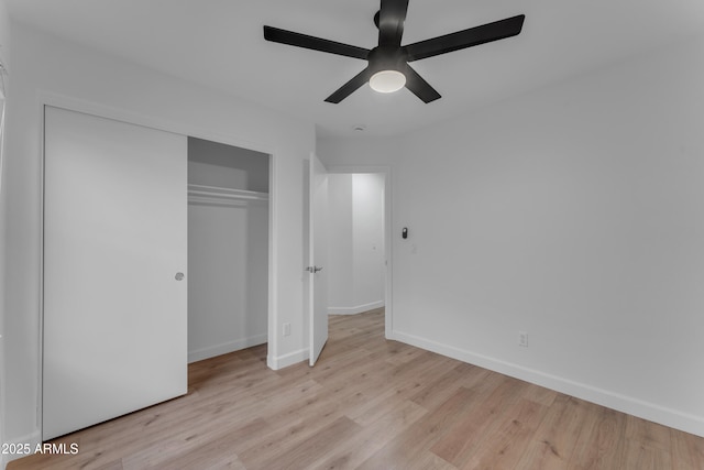 unfurnished bedroom featuring a ceiling fan, a closet, baseboards, and wood finished floors