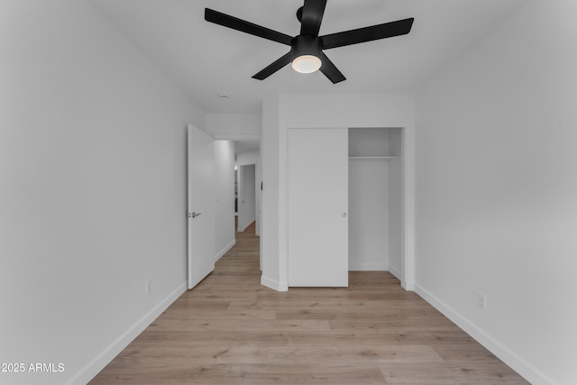 unfurnished bedroom featuring ceiling fan, light wood finished floors, a closet, and baseboards