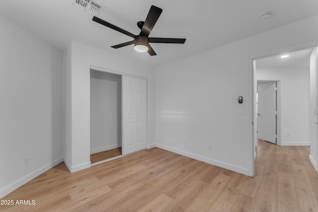 unfurnished bedroom featuring light wood finished floors, baseboards, visible vents, a ceiling fan, and a closet