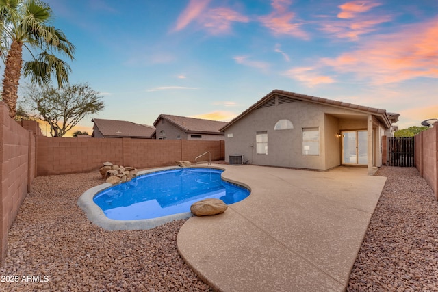 pool at dusk with a fenced in pool, a patio area, central AC, and a fenced backyard