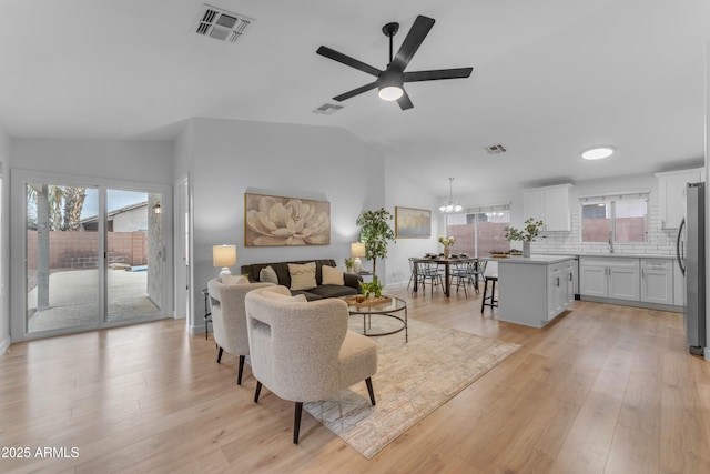 living area featuring light wood-type flooring, visible vents, and plenty of natural light