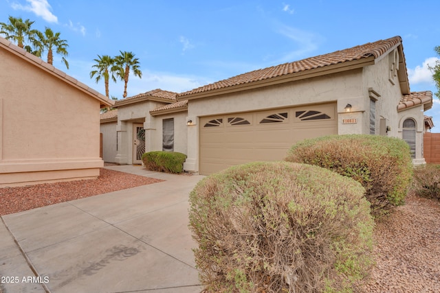 mediterranean / spanish-style house with a garage, a tile roof, and stucco siding