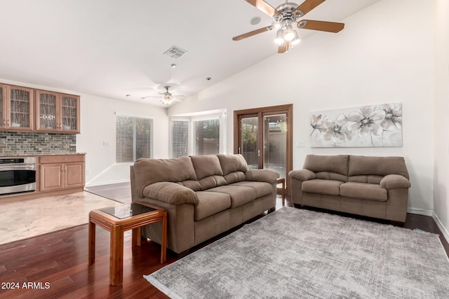 living room featuring high vaulted ceiling, ceiling fan, and dark wood-type flooring