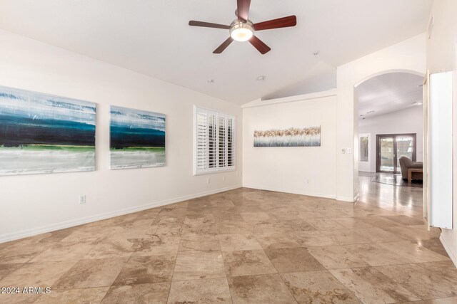 empty room with ceiling fan and lofted ceiling