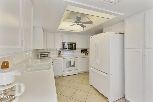 kitchen featuring light tile patterned floors, white appliances, ceiling fan, backsplash, and white cabinets