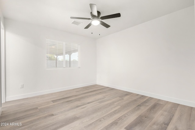 empty room with ceiling fan and light hardwood / wood-style flooring