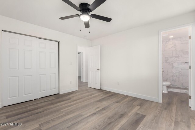 unfurnished bedroom with hardwood / wood-style flooring, ensuite bath, a closet, and ceiling fan