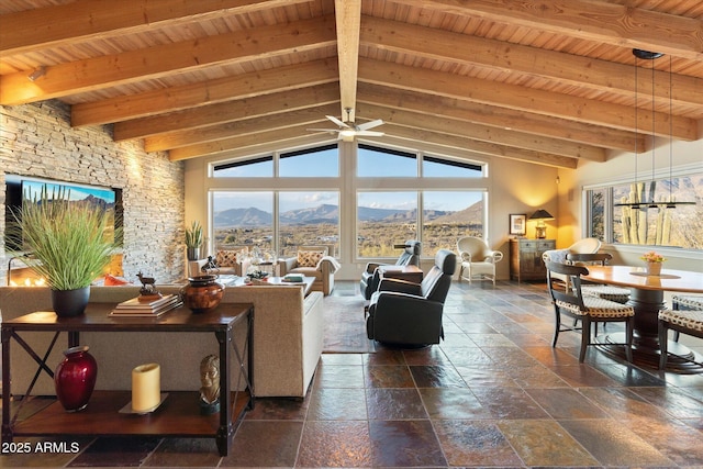 living room with lofted ceiling with beams, ceiling fan, a mountain view, and wood ceiling