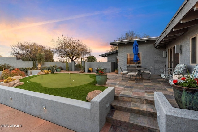 yard at dusk with a patio area